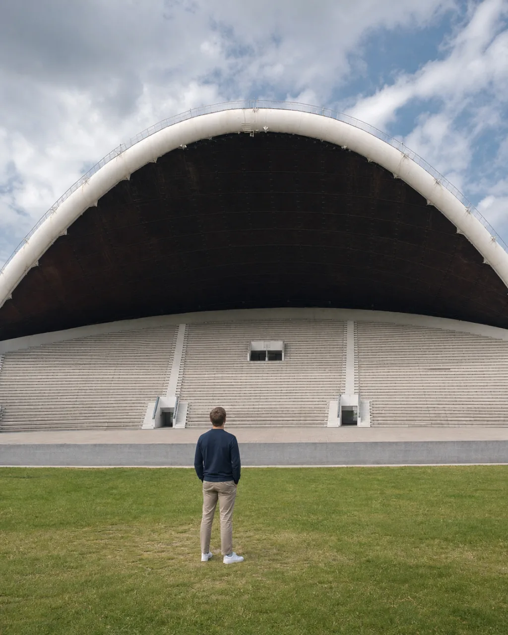 Traveler facing the immense empty Song Festival arch in Tallinn